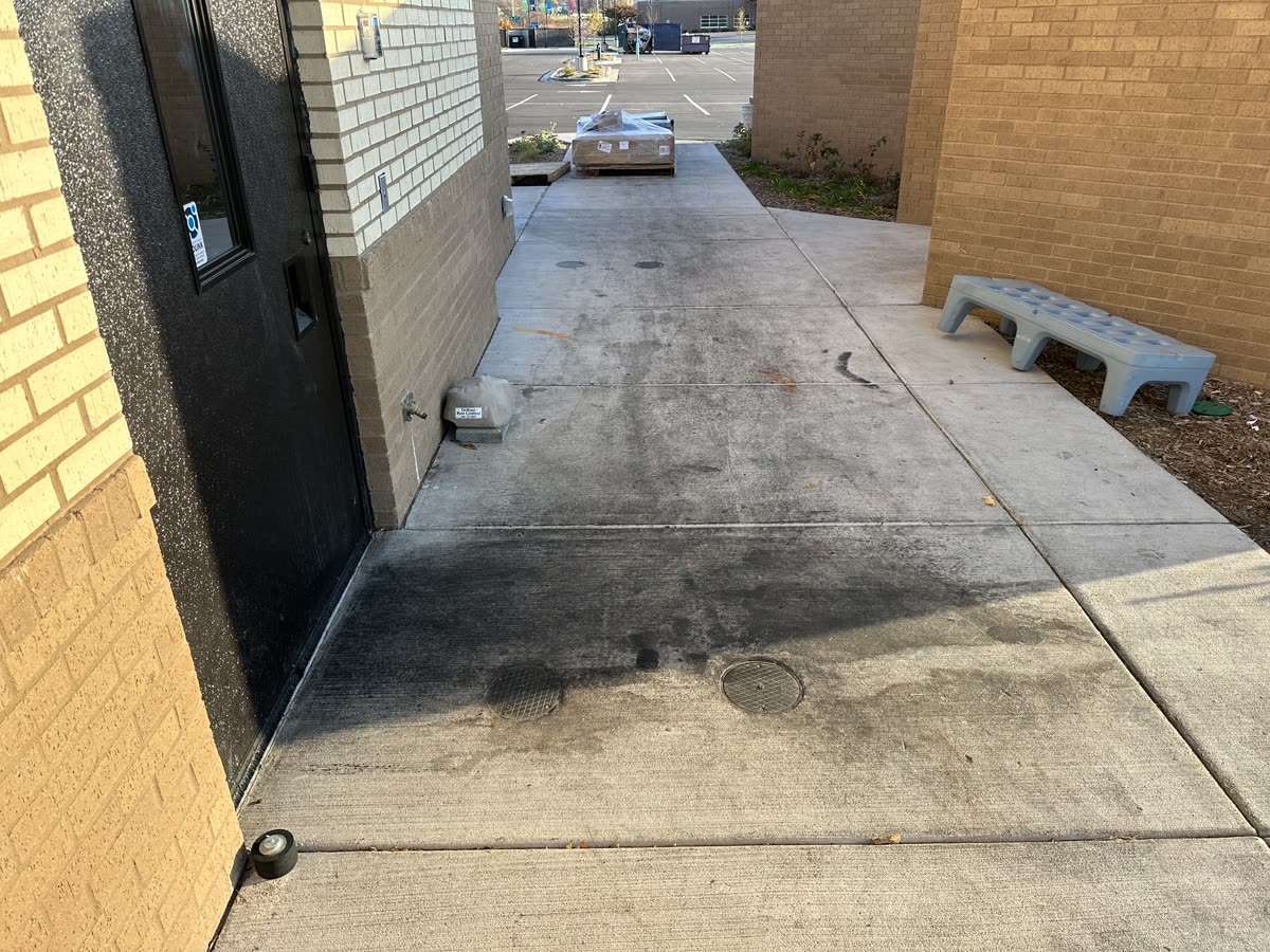 Commercial concrete walkway before cleaning, dark with grime