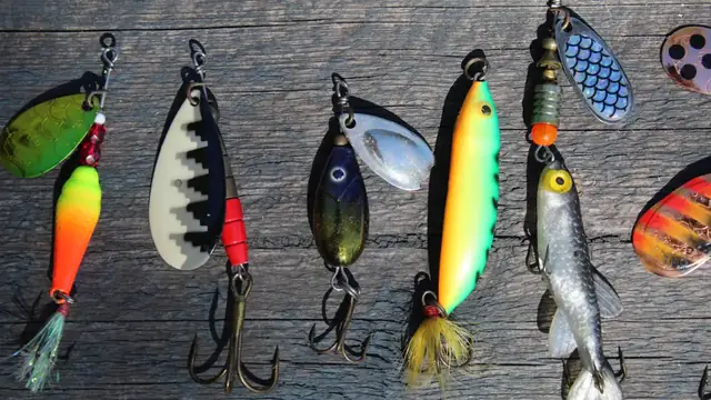 A row of spinners and spoons with treble hooks hanging on a weathered board
