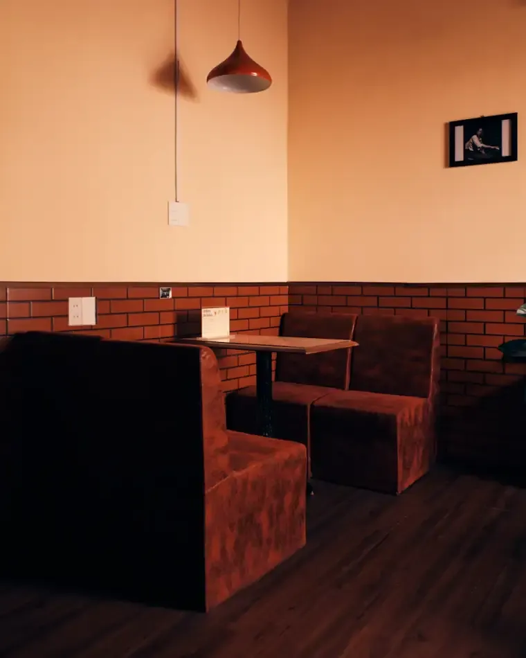 A private corner booth in warm light under two hanging pendant lamps