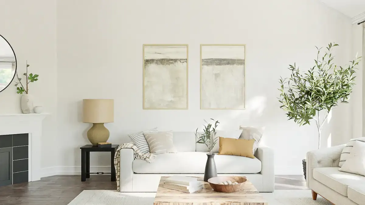 Living room with a white sofa, a fireplace, two lamps and framed art