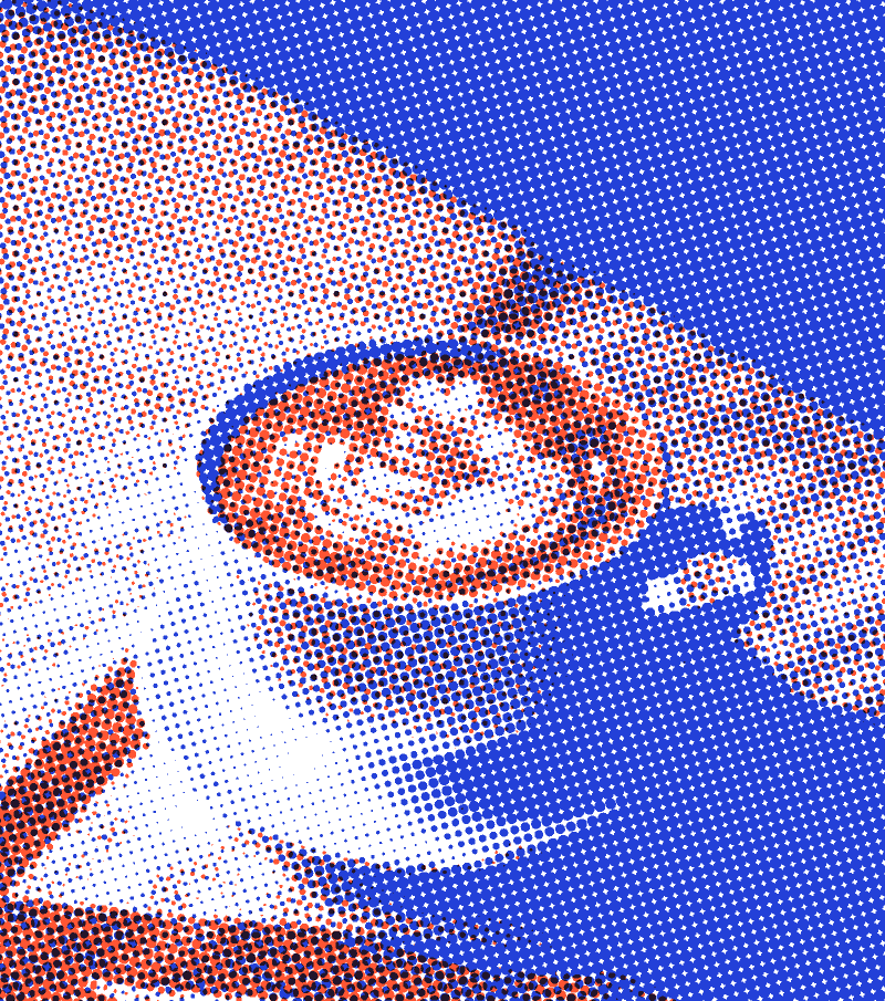 A latte with a leaf poured in the foam, on a saucer, printed in orange and blue dots