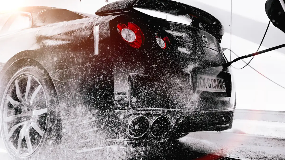 Water spraying off the rear of a black sports car, droplets frozen mid-air