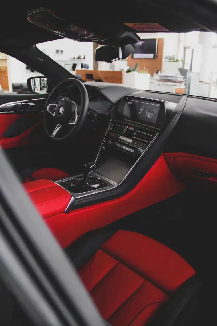Red leather seats and black dashboard of a car interior after cleaning