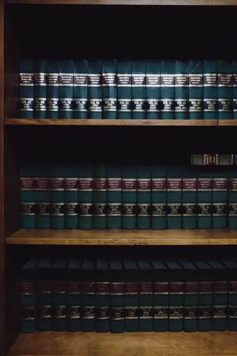 Rows of matching dark blue law books on wooden shelves