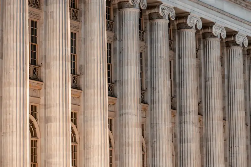 Tall fluted stone columns along the front of a classical courthouse