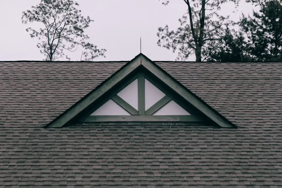 Right: even grey architectural asphalt shingles with a white gable dormer